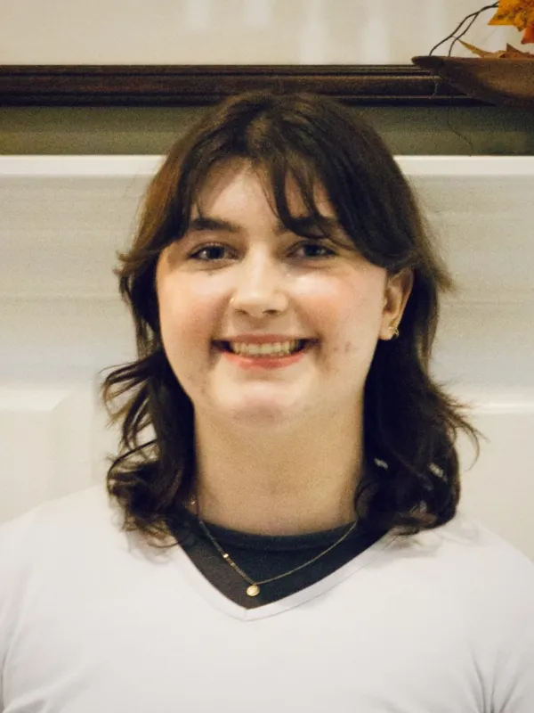 A photo of a woman smiling against a light backgound